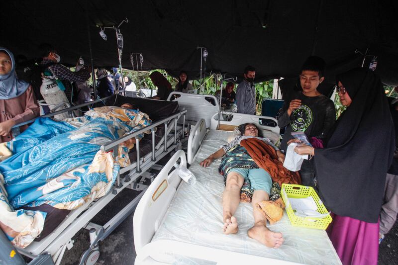Para korban luka-luka mendapatkan perawatan di bawah tenda darurat di halaman sebuah rumah sakit setelah gempa bumi di Cianjur, Jawa Barat, pada 21 November 2022. [STR/AFP]