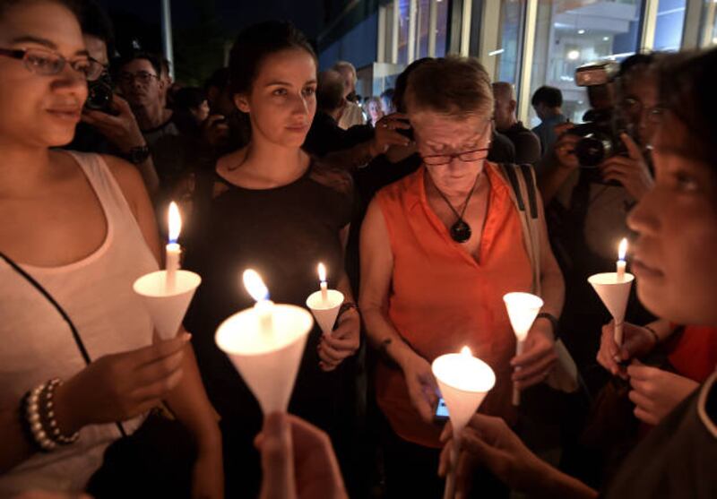 French nationals hold candles during a vigil for victims of a terror attack in Paris at the Alliance Francaise in Bangkok, Nov. 14, 2015. [AFP]