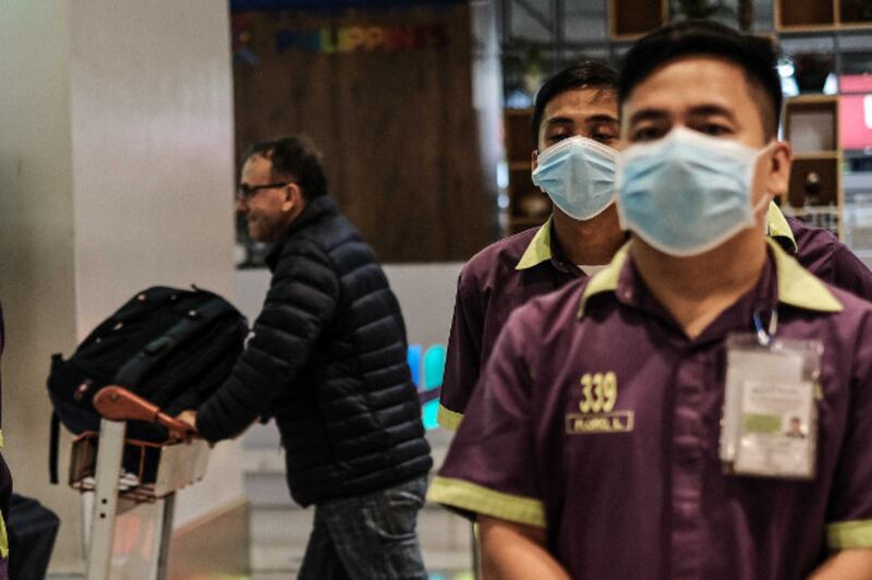 Personnel at Manila's Ninoy Aquino International Airport wear face masks as a precaution against the new coronavirus from China, Jan. 23, 2020. [Jojo Rinoza/BenarNews]