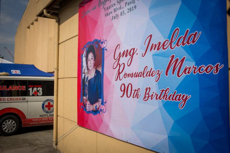 A poster announcing the 90th birthday of former Philippine first lady Imelda Marcos hangs outside the sports complex where party-goers were treated after becoming ill, July 3, 2019. (Luis Liwanag/BenarNews)