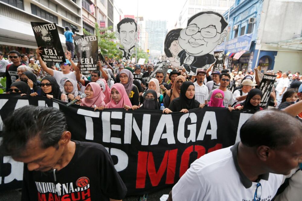 Aktivis penuntut membawa sepanduk sambil berarak menuju ke Dataran Merdeka semasa perhimpunan bagi menuntut penangkapan "Pegawai Malaysia 1" di Kuala Lumpur, 27 Ogos, 2016.