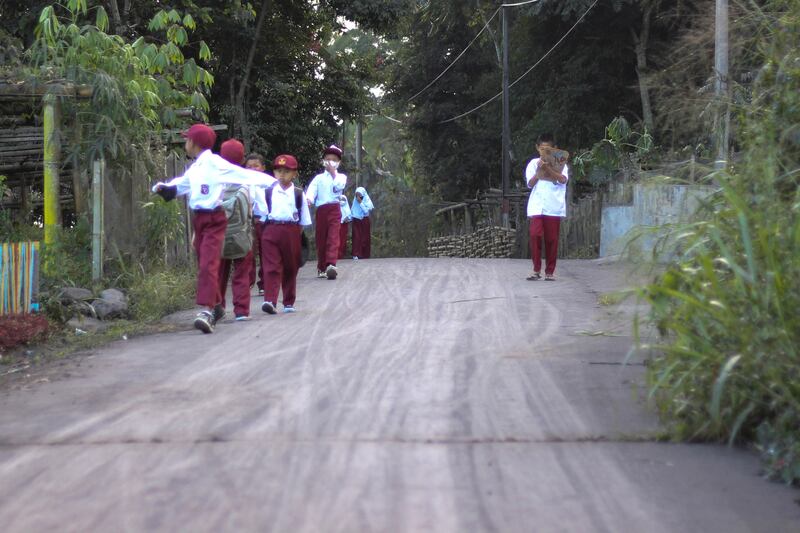 Anak-anak SD berjalan menuju sekolah mereka di Agam, Sumatra Barat, 5 Desember 2023. [Wica Harefa/AP]