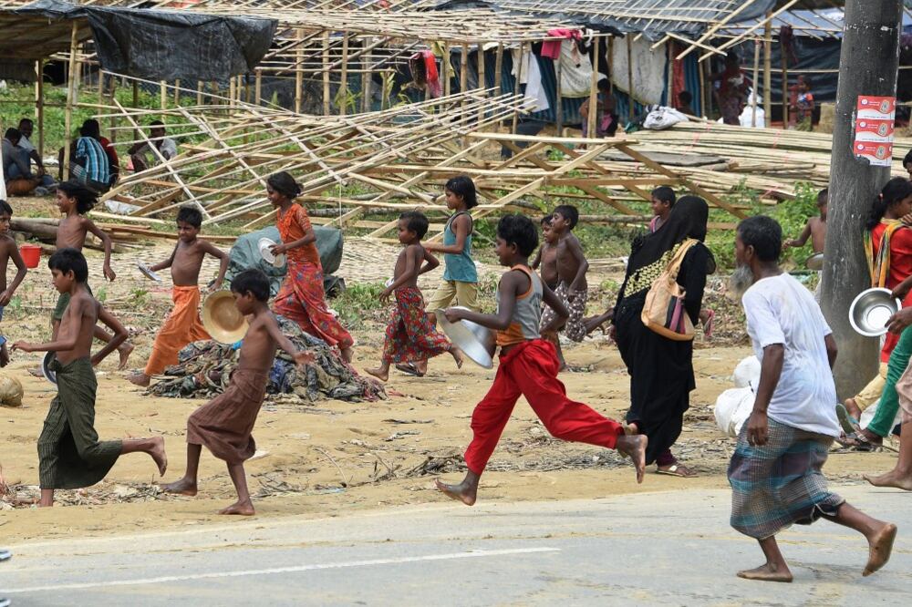 Rohingya refugees run for food being distributed at the Thangkhali refugee camp near Ukhia, Bangladesh, Sept. 27, 2017.