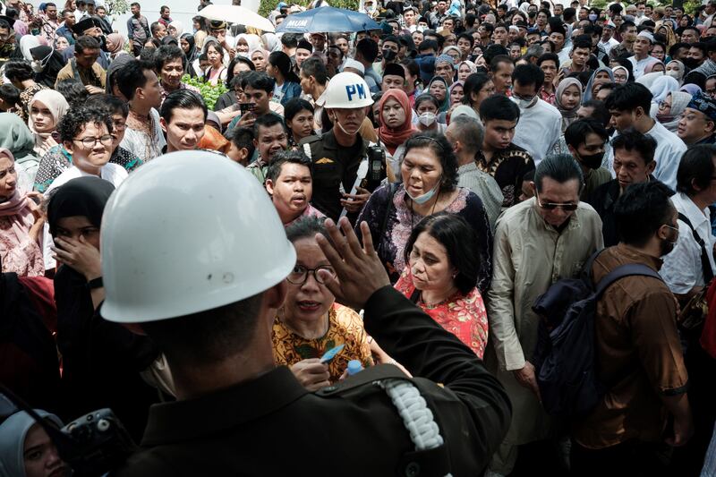 Warga berkumpul untuk menerima bantuan makanan yang didistribusikan oleh Presiden Joko Widodo untuk menyambut Idul Fitri di Istana Kepresidenan di Jakarta pada 10 April 2024. [Yasuyoshi Chiba/AFP]
