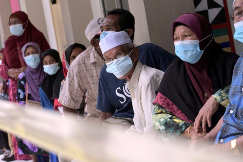 Voters wear masks to help curb the spread of COVID-19 as they wait for their turn to vote in state elections at a polling station near Kota Kinabalu, the capital of Malaysia's Sabah state, Sept. 26, 2020. [AP] 