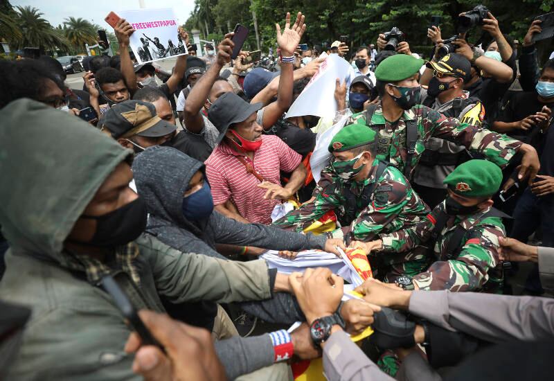 Aktivis Papua bentrok dengan tentara dan petugas polisi yang mencoba menyita spanduk mereka dalam demonstrasi menuntut kemerdekaan Papua, di Jakarta, 19 Desember 2020. [AP]