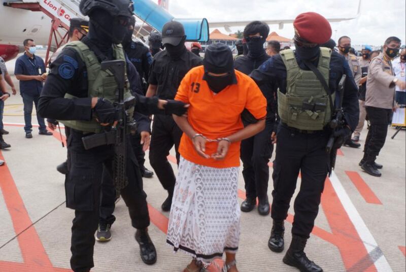 Polisi mengawal Zulkarnaen, 57 tahun, seorang pemimpin senior Jemaah Islamiyah - jaringan Al-Qaeda di Asia Tenggara yang telah lama menjadi buronan karena dugaan perannya dalam bom Bali tahun 2002, setibanya di Bandara Internasional Soekarno-Hatta Jakarta di Tangerang pada 16 Desember 2020. [AFP]