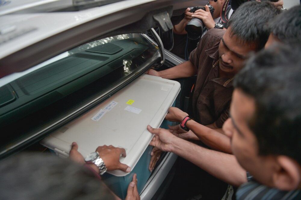 Polis Malaysia meletakkan peralatan yang dirampas ke dalam kenderaan di luar pejabat 1Malaysia Development Berhad (1MDB) di Kuala Lumpur. 8 Julai 2015