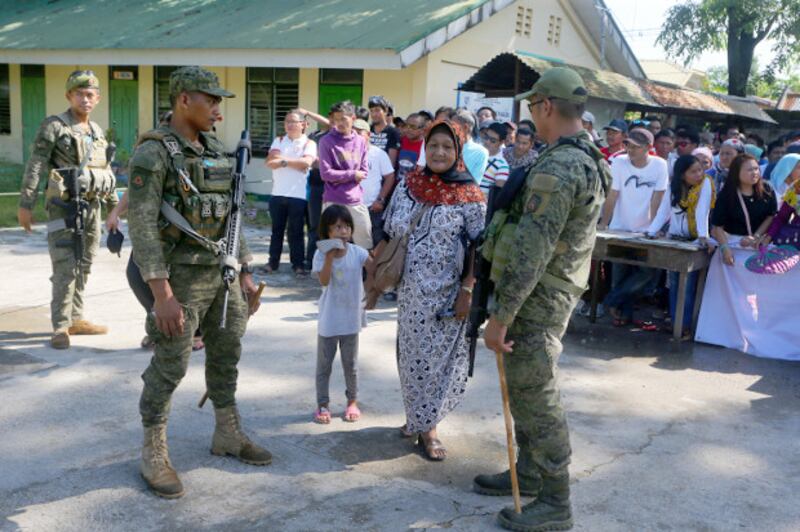 Members of the Philippine Army's 6th Infantry Division provide security as Muslim residents troop to polling centers at a school in Cotabato City's Tamontaka village to cast their votes for the midterm elections, May 13, 2019. [Mark Navales/BenarNews]