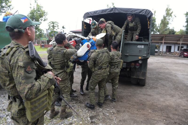 Philippine government troops load a small tractor onto a truck in the town of Butig, southern Philippines, July 28, 2019. [Froilan Gallardo/BenarNews] 