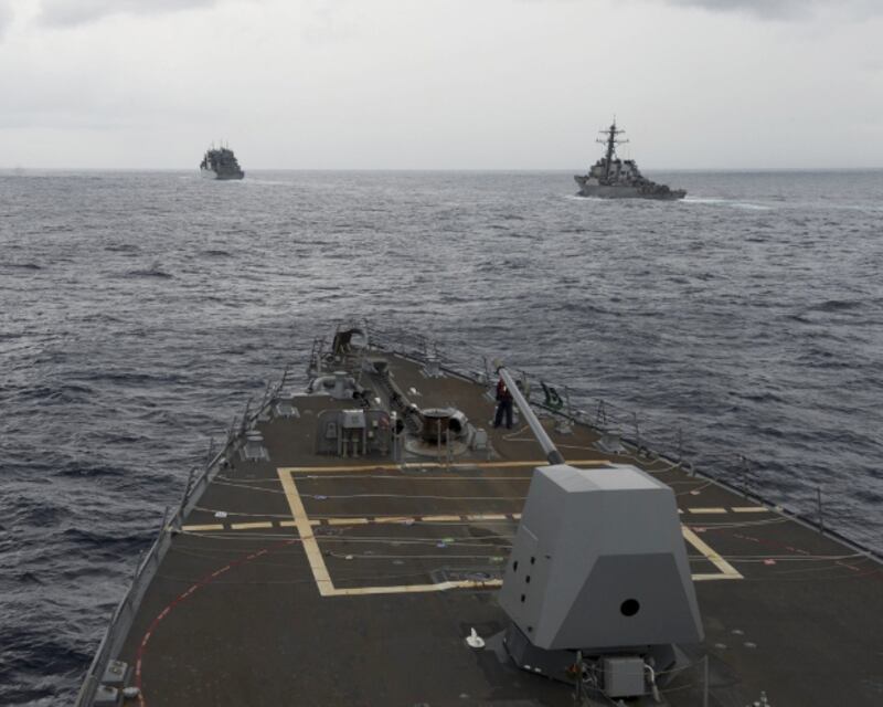 The guided missile destroyer USS Decatur (right) pulls into position behind the Military Sealift Command USNS Matthew Perry, seen from the bridge of USS Spruance, during a freedom-of-navigation operation in the South China Sea, Oct. 21, 2016. [AP]