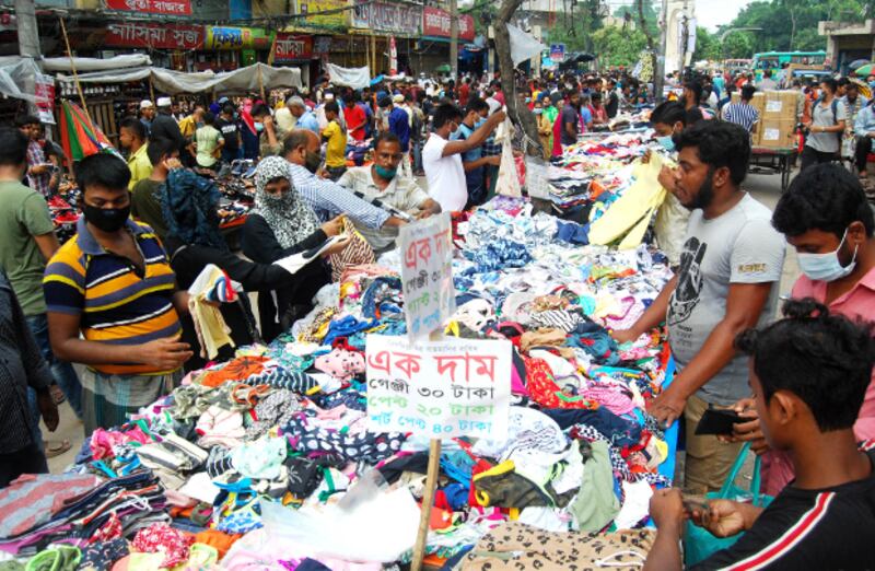 করোনাভাইরাস সংক্রমণের ভয় এড়িয়ে ঢাকার ফুটপাতে শেষ মুহূর্তের ঈদের বাজার করছেন ক্রেতারা। ৩০ জুলাই ২০২০।