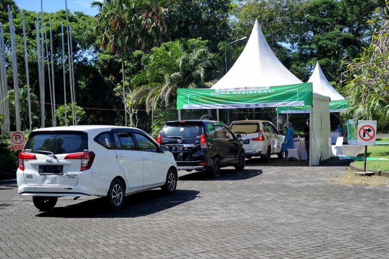 Kendaraan tampak antri di tempat layanan vaksin COVID-19 langsung dari mobil di Nusa Dua, salah satu wilayah dari tiga zona hijau - zona bebas pandemi virus corona di Bali, 1 Maret 2021. [AFP]