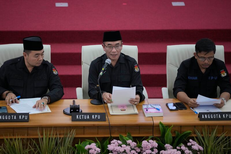 Hasyim Asy'ari, Ketua Komisi Pemilihan Umum (tengah), didampingi anggota KPU Mochammad Afifuddin (kiri) dan Idham Holik, mengesahkan hasil Pemilu 2024 di kantor KPU di Jakarta, 20 Maret 2024. [Dita Alangkara /AP]