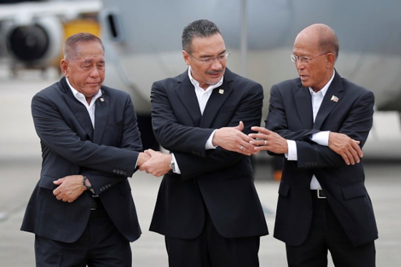 Indonesian Defense Minister Ryamizard Ryacudu (left) joins hands with his counterparts from Malaysia, Hishammuddin Hussein, and the Philippines, Delfin Lorenzana, for a group photo after the launch of joint air patrols at Subang military airbase in Petaling Jaya, Malaysia, Oct. 12, 2017. (AP)