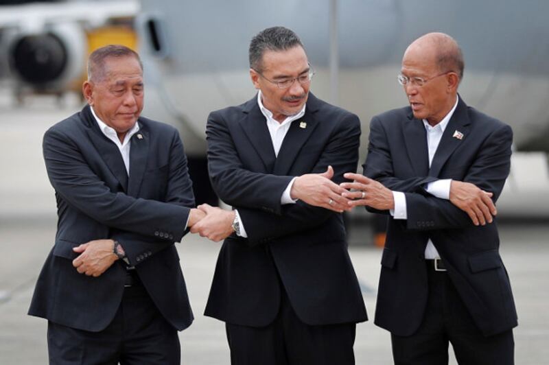 Indonesian Defense Minister Ryamizard Ryacudu (left) joins hands with his counterparts from Malaysia, Hishammuddin Hussein, and the Philippines, Delfin Lorenzana, for a group photo after the launch of joint air patrols at Subang military airbase in Petaling Jaya, Malaysia, Oct. 12, 2017. (AP)