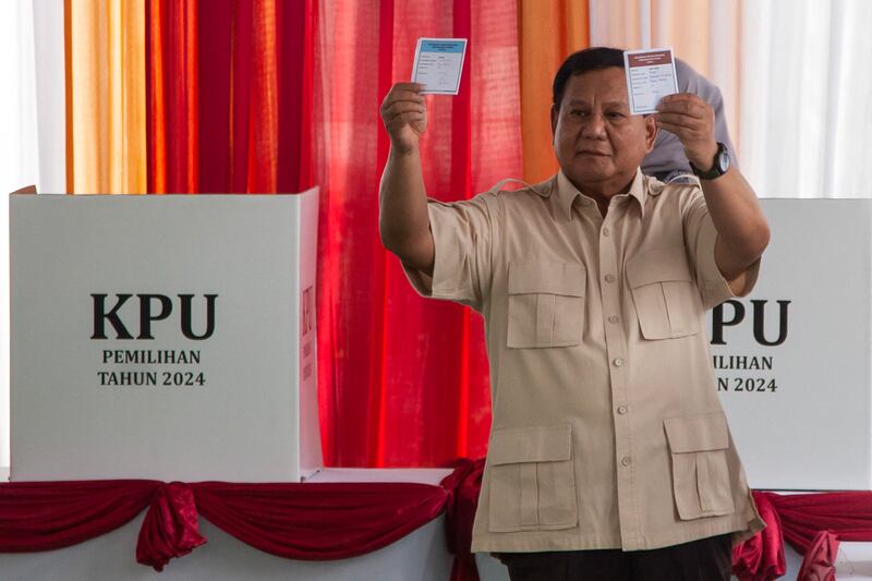 Presiden Prabowo Subianto menunjukkan surat suara saat memberikan suara dalam pemilihan kepala daerah (Pilkada) serentak di Bogor, Jawa Barat pada 27 November 2024. [Aditya Irawan/AFP]