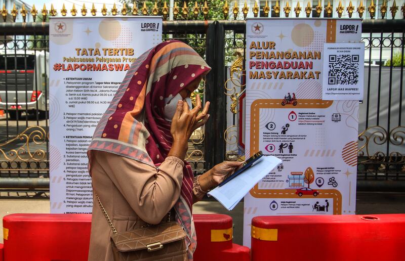 Seorang warga mencermati formulir daring “Lapor Mas Wapres” di Istana Wakil Presiden di Jakarta, 21 November 2024, layanan yang dibuka setiap Senin hingga Jumat pukul 08.00 hingga 14.00 WIB dengan kuota 50 orang per hari. [Eko Siswono Toyudho/BenarNews]