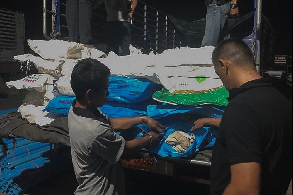 Seorang suspek yang ditahan di daerah Chumphon di selatan Thailand sedang menunjukkan sebahagian daripada dadah yang disembunyikan di dalam karung baja, 19 Julai, 2018.