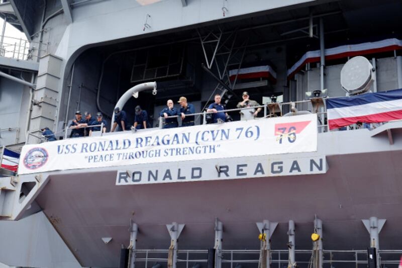 Crew members of the USS Ronald Reagan unfurl a banner on the ship's deck, Aug. 7, 2019. [Jason Gutierrez/BenarNews]