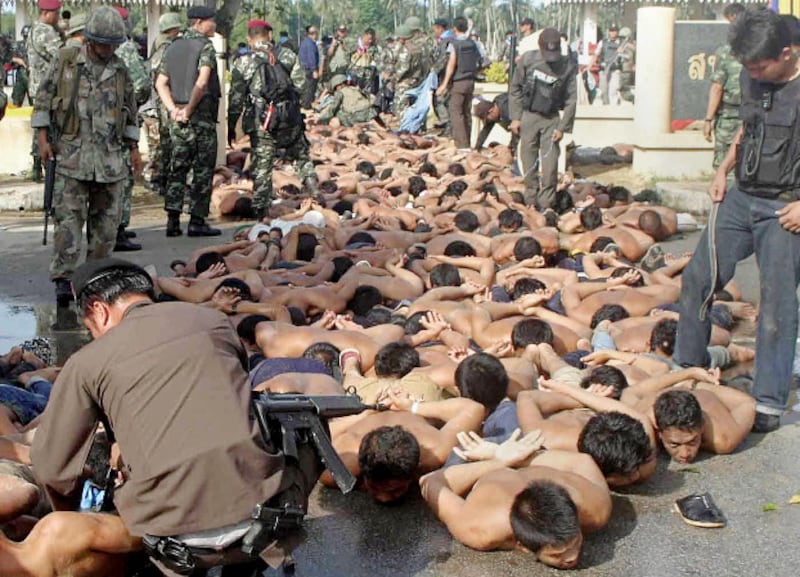 Demonstrators lie on the pavement after their arrest oustide Tak Bai police station in Narathiwat province, Thailand, Oct. 25, 2004.