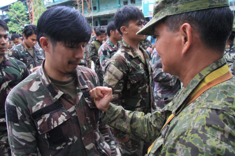 Lt. Gen. Rolando Joselito Bautista, Philippine Army chief, pins a Special Forces badge to the graduates of Special Forces and Scout Rangers after five months of fighting against Islamic State militants in Marawi city, Oct. 23, 2017.