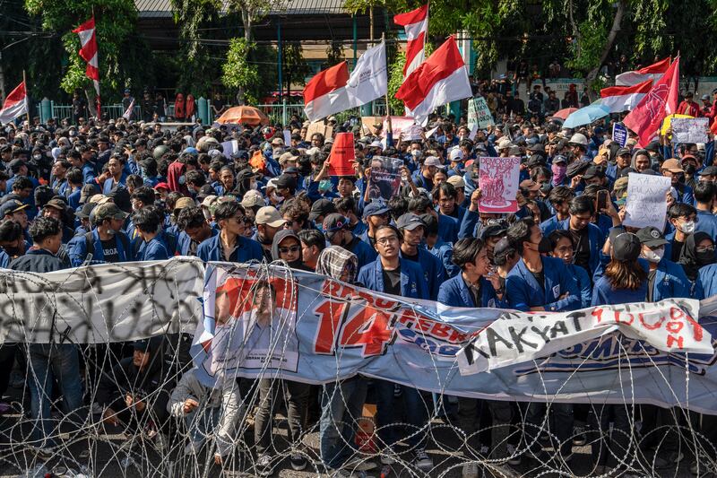 Orang-orang memegang poster dalam aksi protes menentang upaya untuk membatalkan keputusan Mahkamah Konstitusi yang mengubah aturan kelayakan kandidat dalam pemilihan kepala daerah, di depan gedung DPRD Provinsi Jawa Timur, Surabaya, 23 Agustus 2024. [Juni Kriswanto/AFP]