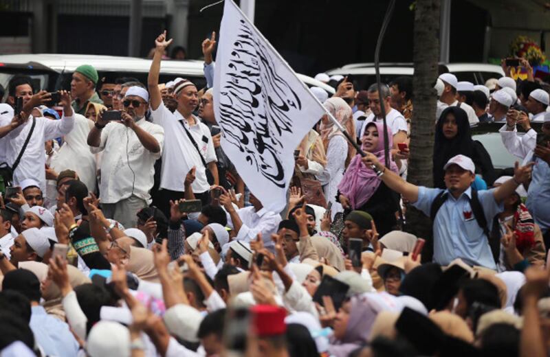 Seorang pendukung calon presiden Prabowo Subianto membawa bendera bertuliskan kalimat Tauhid saat acara syukuran kemenangan di Jakarta, 19 April 2019. (Keisyah Aprilia/BeritaBenar)