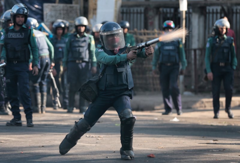 A Bangladeshi police officer fires tear gas at demonstrators protesting against plans to build a coal-fired power plant, in Dhaka, Jan. 26, 2017. (AP)
