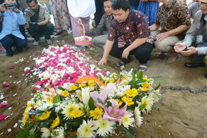 Muhammad Ivanka Rizaldy Nugroho prays at his father's grave, July 8, 2019. [Kusumasari Ayuningtyas/BenarNews]