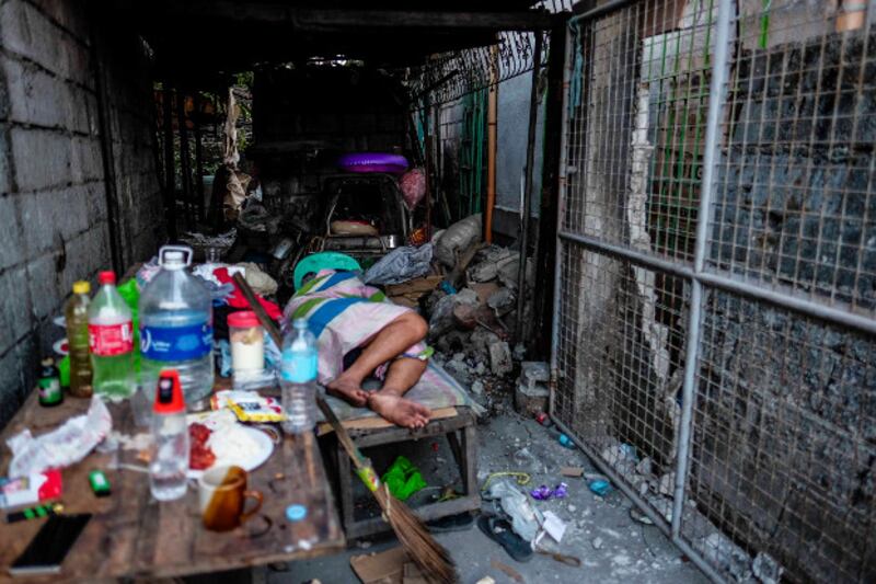 A man sleeps outside his house in Porac after Monday's earthquake, April 23, 2019. [Jojo Rinoza/BenarNews]