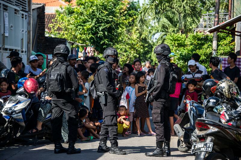 Anggota Densus 88 mengepung jalan saat mereka menggeledah sebuah rumah menyusul penangkapan seorang laki-laki yang dicurigai memiliki hubungan dengan kelompok militan Negara Islam (ISIS), di Surabaya, Jawa Timur, 19 Juni 2017. [Juni Kriswanto/AFP]