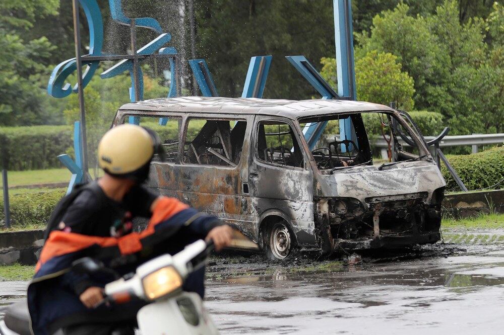 Sebuah kenderaan musnah terbakar di luar pejabat pemaju hartanah MCT Berhad di Subang, di negeri Selangor, selepas kekecohan berlaku berhubung pertikaian mengenai penempatan semula sebuah kuil Hindu, 27 November 2018.