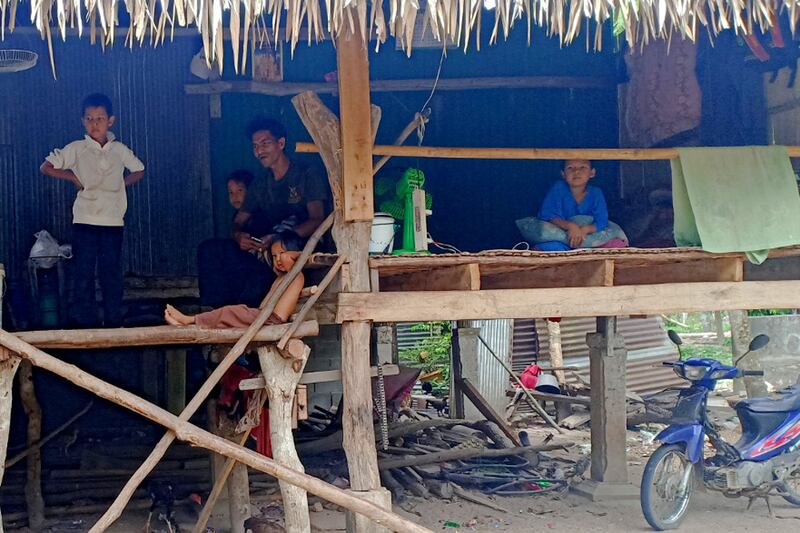 Sa-ari Baharo, a widower with five children, sits in his home with his children in Baro, a sub-district in Yala province, April 30, 2020.