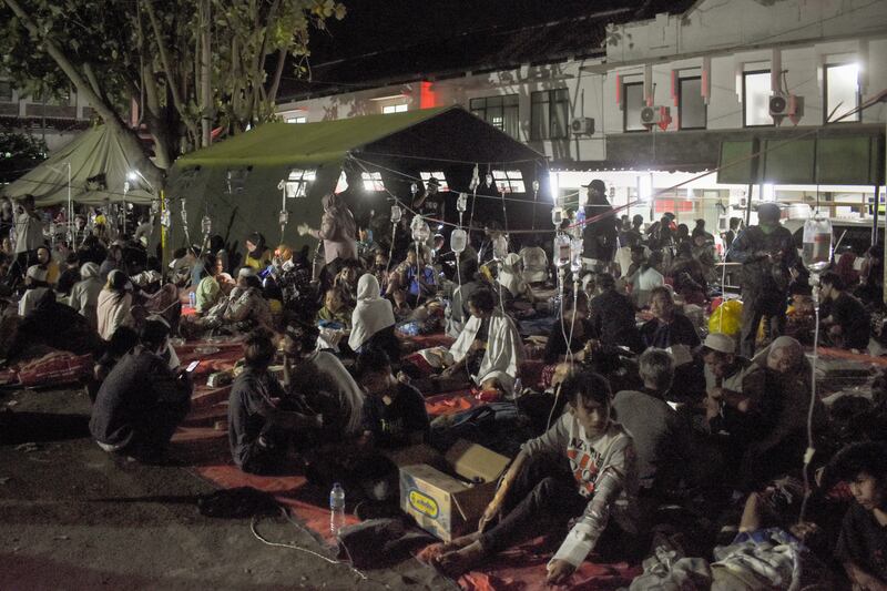Para penyintas yang terluka akibat gempa dirawat di halaman sebuah rumah sakit di Cianjur, Jawa Barat, pada 21 November 2022. [Timur Matahari/AFP]