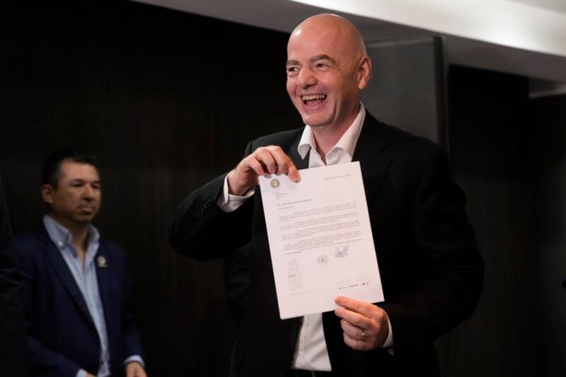 Presiden FIFA Gianni Infantino memegang surat dari Asosiasi Sepak Bola Argentina yang menawarkan untuk menjadi tuan rumah Piala Dunia U-20 2023 menggantikan Indonesia, di Asunción, Paraguay, 30 Maret 2023. [Jorge Saenz/AP Photo]