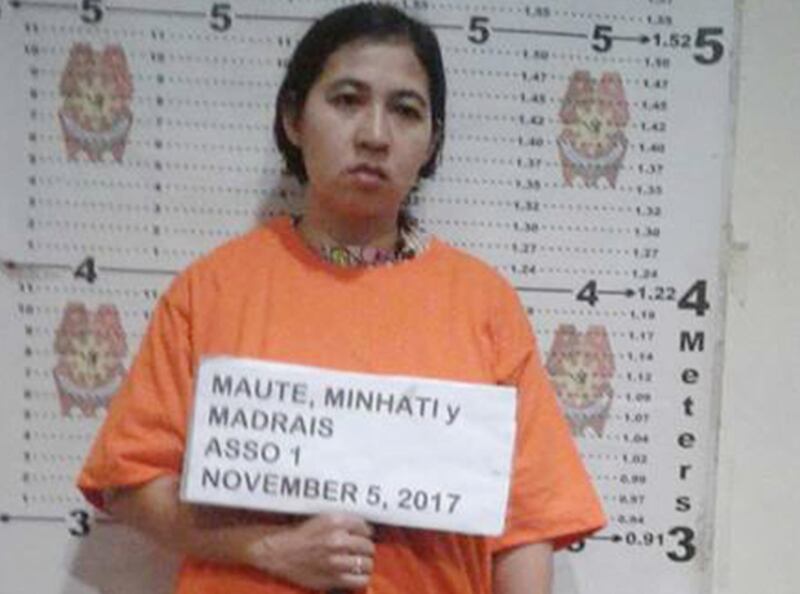 Minhati Madrais, janda militan Omarkhayam Maute, memegang tulisan namanya di kantor polisi di kota Iligan, Filipina, sesaat setelah ia ditangkap 5 November 2017. (Kepolisian Filipina)