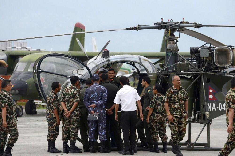 Personnel at a base in Kathmandu gather in front of a Nepalese helicopter, whose crew spotted the wreckage of a missing U.S. Marine helicopter, May 15, 2015.