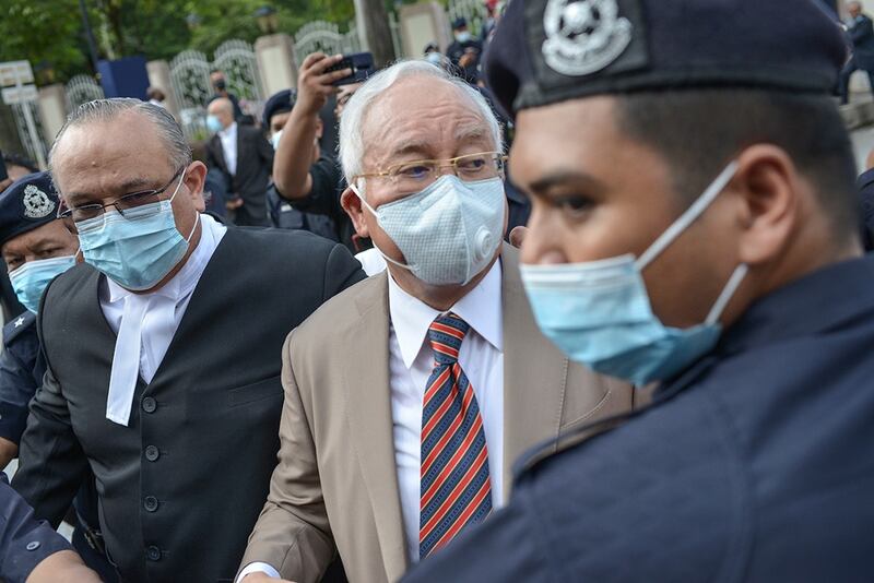 Former Malaysian Prime Minister Najib Razak (center) arrives at the Kuala Lumpur High Court for the verdict in the first of his corruption trials linked to the 1MDB financial scandal, July 28, 2020.