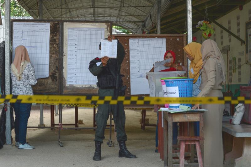Security personnel and electoral officials count votes at a polling station after polls closed in Narathiwat, a province in Thailand's troubled Deep South, March 24, 2019. [AFP]