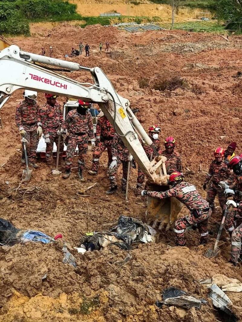 Anggota Jabatan Bomba dan Penyelamat Malaysia menggunakan jengkaut untuk mengeluarkan mayat mangsa yang dijumpai di lokasi tanah runtuh di Father's Organic Farm, Batang Kali, Gohtong Jaya di Selangor pada 21 Di 2022. [Gambar Ihsan Jabatan Bomba dan Penyelamat Malaysia]