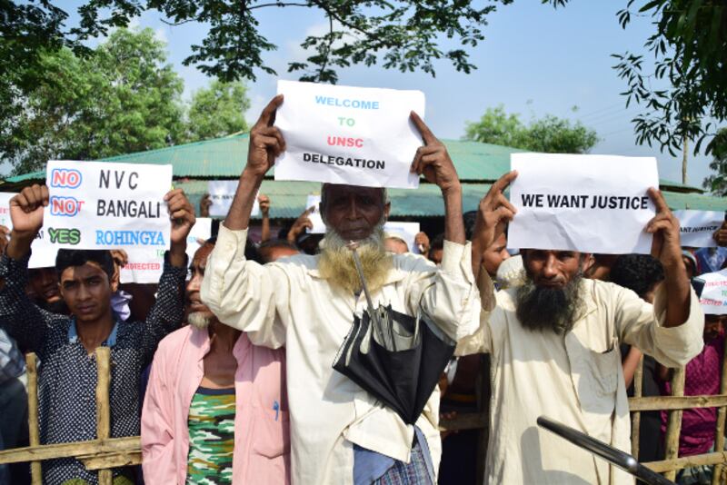 Rohingya refugees hold up placards while U.N. Security Council delegates visit the Kutupalong refugee camp in Ukhia, Cox's Bazar, April 29, 2018.