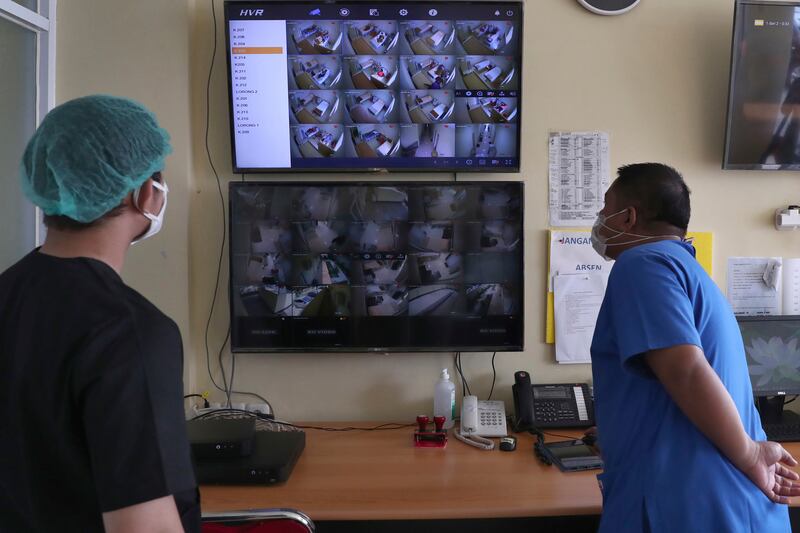 Dr. Irman Pahlepi (kiri) memeriksa layar monitor pasien COVID-19 di Rumah Sakit Umum Dr. Suyoto di Jakarta pada 29 Juli 2021. Dr. Pahlepi kembali bekerja setelah sembuh dari COVID-19 untuk kedua kalinya. Dengan jumlah infeksi di Indonesia yang meroket pada saat itu dan jumlah kematian yang meningkat termasuk dari tenaga medis, Pahlepi merasa dia tidak punya pilihan selain segera kembali bekerja. [Tatan Syuflana/AP]