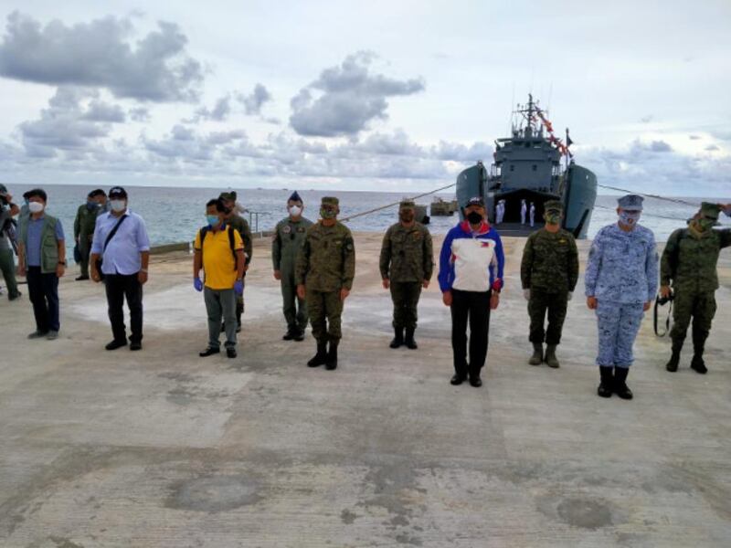 Philippine Defense Secretary Delfin Lorenzana (in white and blue jacket) joins defense officials as he inaugurates a beaching ramp on Pag-asa (Thitu) Island in the South China Sea, June 9, 2020. (Handout Philippine Department of Defense)