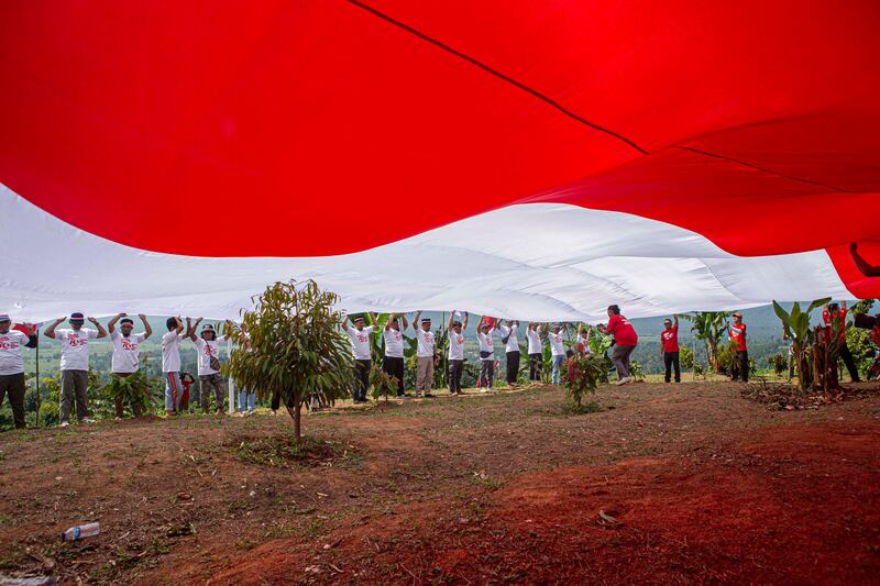 Sejumlah mantan narapidana terorisme mengikuti kegiatan pembentangan bendera merah putih di kaki Gunung Biru, Desa Pantangolemba, Kecamatan Poso Pesisir Selatan, Poso, Sulawesi Tengah, Jumat, 16 Agustus 2024. [Taufan Bustan/BenarNews]