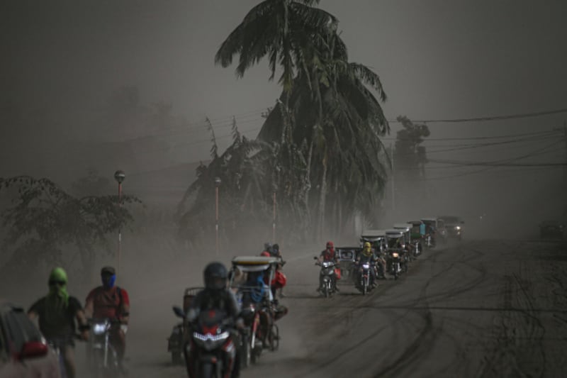 A convoy of motorcycles heads away from Agoncillo town in Batangas province to escape the ash from the Taal Volcano eruption, Jan. 13, 2020. [Jojo Riñoza/BenarNews]