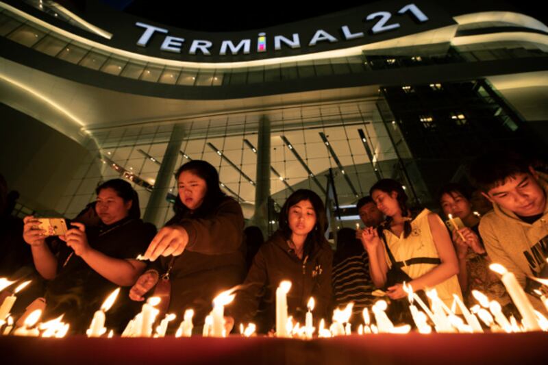 People light candles during a memorial service at Terminal 21 shopping center in Nakhon Ratchasima, Thailand, Feb. 10, 2020. (AP)
