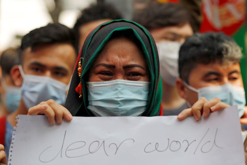 Seorang perempuan Afghanistan membentangkan sebuah poster dalam unjuk rasa di luar gedung Badan Pengungsi PBB (UNHCR) di Jakarta, 24 Agustus 2021. [Reuters]