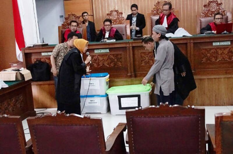 Prosecutor Mayasari (left) shows the books written by Aman Abdurrahman (right) at the South Jakarta Court, April 27, 2018.