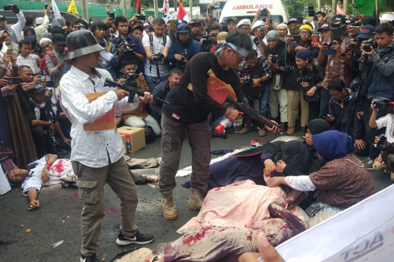 Protestors perform a theatrical depiction of alleged torture of Uyghur Muslims during a demonstration outside the Chinese embassy in Jakarta, Dec. 21, 2018. [Rina Chadijah/BenarNews]